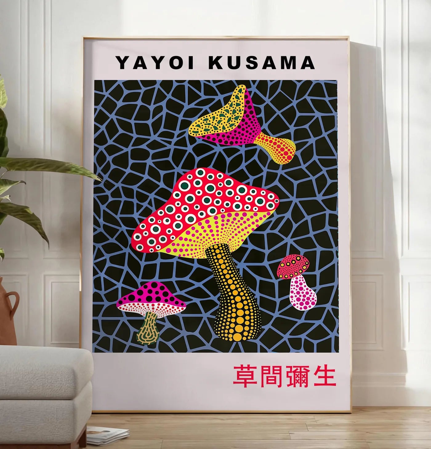 Reproduction affiche champignons rouge de Kusama art japonais, posee au sol dans un salon minimaliste clair, a cote d'un canape beige et d'une plante verte, sur un parquet clair