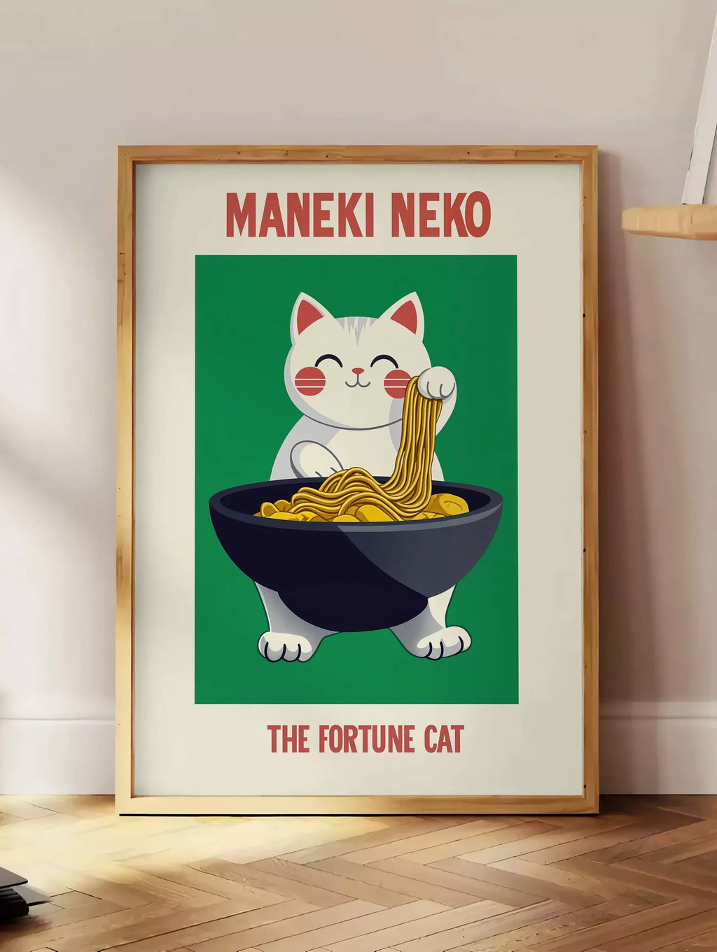 Estampe affiche Maneki Neko chat porte-bonheur attrapant des ramen au-dessus d'un bol noir, posee au sol dans un coin salon, sur un parquet a chevrons, pres d'une table d'appoint en chene chargee de livres