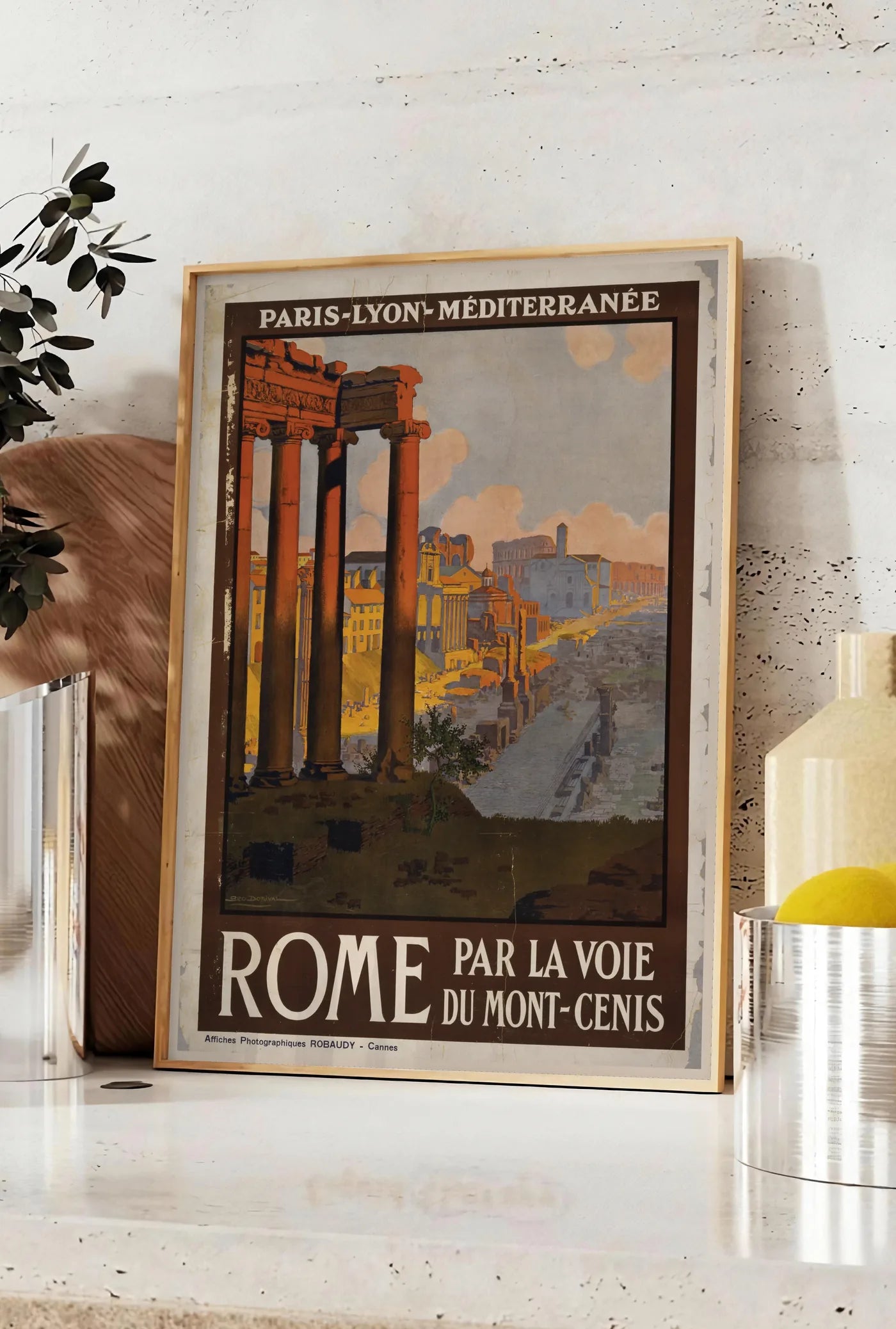 Affiche affiche Rome vintage PLM, posee sur un plan de travail de cuisine en pierre claire, entre une branche d'eucalyptus en vase et un bocal de citrons